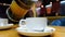 Close up of man pouring hot tea into white cups.Vitamin citrus tea in cafe.