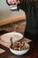 Close-up of a man pouring oil over a salad