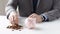 Close up of man putting coins into piggy bank