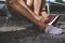 Close-up of man putting on sock and shoes before workout