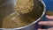 Close-up. a man removes boiled malt from a brewing pan