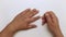 Close-up man removes cuticle with an orange stick.