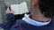 Close up of man in retro suit sitting on bench and read book, back view