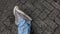 Close-up of a man's feet in jeans and casual shoes on the block floor