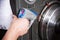 Close-up of a man`s hand with a device measures the ignition phase at the stand for setting up fuel equipment