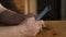 Close-up of a man\'s hand dialling a number on a cell phone with his fingers.