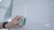 close-up of a man's hand erasing a marker from a white board with a green sponge after a meeting.