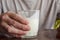 Close-up of man`s hand with half-empty glass of kefir