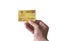 Close-up of Man`s hand holding yellow gold plastic credit card isolated on white background