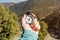 Close-up A man`s hand holds a pocket compass against the backdrop of mountains and woods. The concept of outdoor