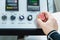 Close-up of a man`s hand on a red button on the control panel. Emergency stop or start of equipment and production