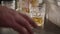 A close-up of a man\\\'s hand takes a glass of alcohol Footage without color correction