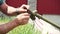 Close-up of a man\'s hand taking apart a lawn mower to replace parts. Maintains and repairs the weed cutter by