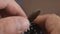 Close-up of a man`s hand wearing a nylon khaki strap on a mechanical diver`s wristwatch.