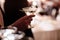 A close up of a man`s hand who is dressed in formal attire and holding a martini glass on party background