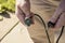 Close-up of man`s hands getting ready to plug three prong American electrical cord into worn green extension cord