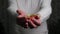 Close-up of a man`s hands holding out a red gift box. Gift giving concept.