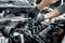 Close up of man`s hands using wrench to remove spark plugs