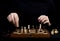 Close-up of the man's hands, which transposes a pawn on a woode