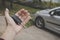 Close up of man`s palm holding car key on a parked car background. Driver holds the vehicular key on the way to the