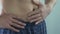 Close-up of man\'s stomach, male squeezing his belly at bathroom, close-up
