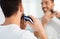 Close up of man shaving beard with trimmer