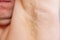 close-up. a man sniffs an unshaven armpit.