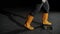 Close-up of man standing on scales. Close-up of worker`s feet in jeans and rubber boots stand on scales lying on gray