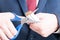 Close-up of man in suit cutting bunch of cigarettes