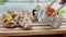 Close-up of a man taking sushi sticks from wooden stand in restaurant overlooking rice fields. Delicious sushi in