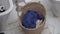 Close-up, a man throwing dirty clothes into a laundry basket