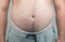 Close up of Man touching his fat belly, Men`s hand holding excessive belly fat. Being overweight is one of the leading