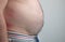 Close up of Man touching his fat belly, Men`s hand holding excessive belly fat. Being overweight is one of the leading