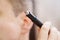 close-up. a man with trimmers for cutting hair in nose and ears. selective focus