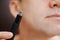 close-up. a man with trimmers for cutting hair in nose and ears. selective focus