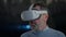 Close-up man in VR headset looking around standing in snow cave with stalactites at background. Portrait of confident