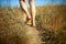 Close up of man walking on field barefoot. Conceptual photo about foot health and nature.