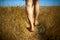 Close up of man walking on field barefoot. Conceptual photo about foot health and nature.