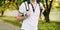 Close-up man walking in the park in a white T-shirt with a backpack on his shoulders.