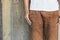 Close up man wearing a white shirt, brown pants standing at wood wall background with copy space. Hipster, Vintage, minimal style