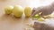 Close-up of a man in white gloves peeling potatoes to make fries,