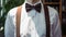 Close-up of a man in white shirt, braces and a bow tie