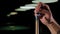 Close up of a man wipes a cue with chalk ready to start game.