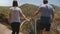 Close-up man and woman walk together holding hands at epic beautiful view of Bixby Creek bridge in Big Sur California.