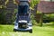 Close Up Of Man Working In Garden Cutting Grass With Mower