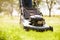 Close Up Of Man Working In Garden Cutting Grass With Mower