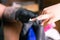 Close-up of manicurist woman removes gel shellac polish from client`s nails using manicure machine. Manicure master is