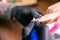 Close-up of manicurist woman removes gel shellac polish from client`s nails using manicure machine. Manicure master is