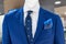 Close up of a mannequin in a store in blue jacket, with a blue tie and scarf.