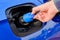 Close up mans hand opening a tank for Ad Blue fluid of a blue car. Diesel exhaust fluid or DEF for reduction of air pollution,